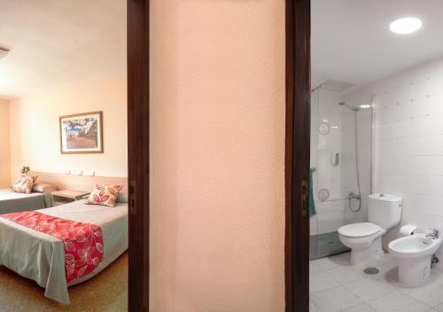 英格兰海滩拉斯贡多拉公寓的一间卧室配有一张床,浴室设有卫生间
