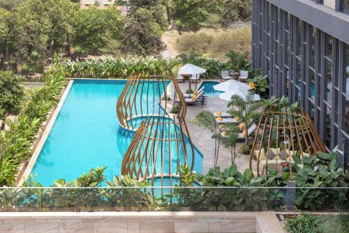 纳西克Radisson Blu Hotel & Spa, Nashik的享有带桌椅的游泳池的顶部景致