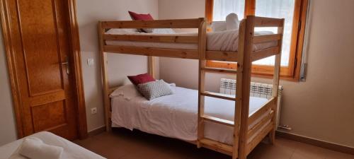 萨尔德斯HOSTAL RURAL CAL XIC Saldes的一间卧室设有两张双层床和一扇窗户。