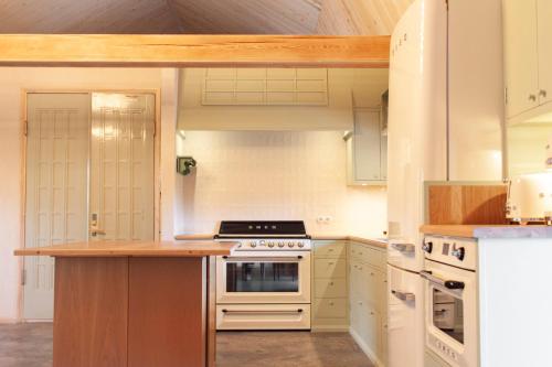 MäntsäläPinewood Guesthouse的厨房配有白色橱柜和炉灶烤箱。