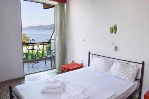 科尔夫斯Hotel Korfos - Ξενοδοχείο Κόρφος Renovated的一间卧室设有一张床,享有海景
