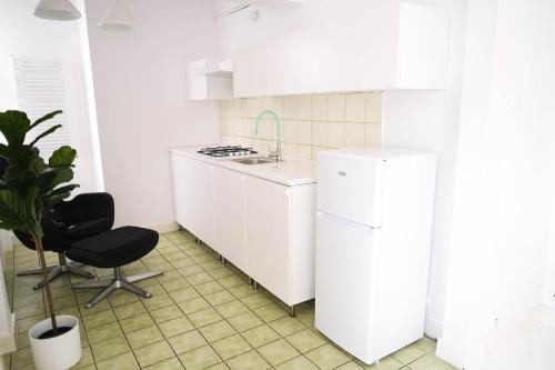 姆拉哥沃Apartamenty Mrągowo Warszawska Cudo Studio的白色的厨房配有白色冰箱和椅子