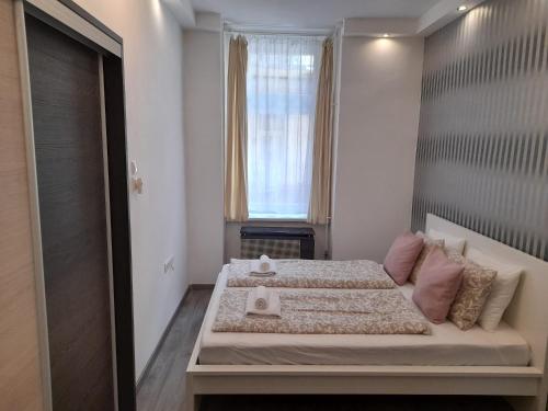 布达佩斯Budapest Central Andrassy Apartment的一间卧室设有一张大床和一个窗户。