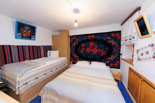 CongazGagauz Sofrasi的卧室设有两张床,墙上挂有挂毯
