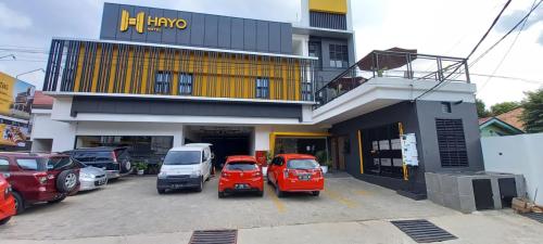 SukaramiHayo Hotel Palembang的停在大楼前停车场的一群汽车