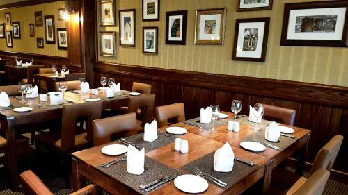 东伦敦摄政普瑞米尔酒店的用餐室配有木桌和椅子