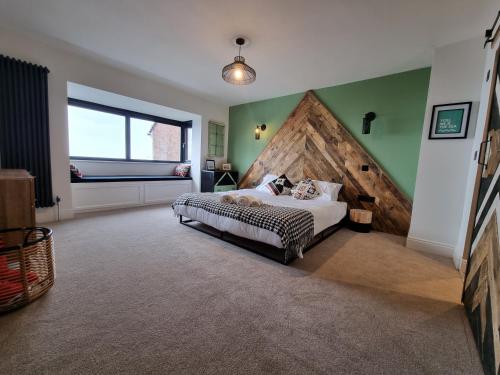 滨海索尔特本Salt & Surf-Sea Views in Saltburn的一间卧室配有一张大床和大型木制床头板