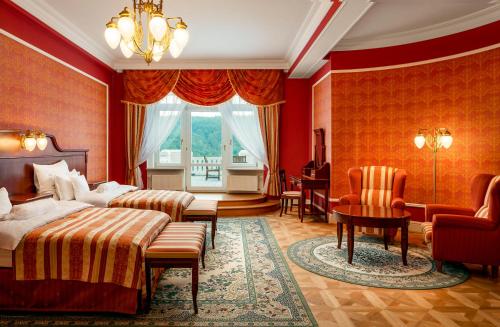 卡罗维发利Spa Hotel Imperial的一间卧室配有两张床和一张桌子及椅子