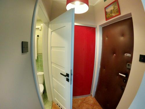鲁恰内尼达Faryna Apartament的浴室设有红色的门和镜子