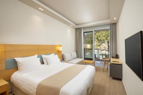 帕莱欧卡斯提撒Akrotiri Beach Resort Hotel - Adult Friendly的酒店客房,配有床和电视