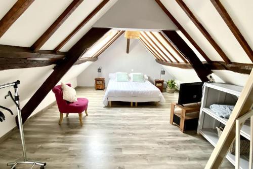 勒克罗图瓦Les Lilas de Mer的阁楼卧室配有床和红色椅子