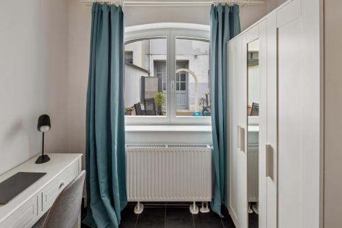 柏林Urban city home的一间卧室配有蓝色窗帘和窗户
