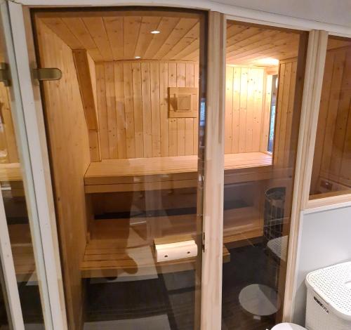 SkalandSenja, Skaland apartment的一间设有木墙和玻璃门的桑拿浴室