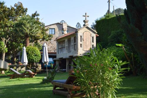 布埃乌Casa Videira - Hotel rural cerca del mar的草丛中的小房子花园