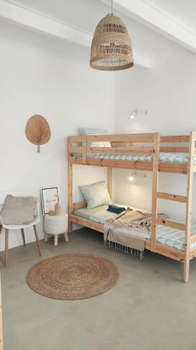 科拉雷侯NOMAD SURF HOUSE的客房设有双层床、桌子和椅子。