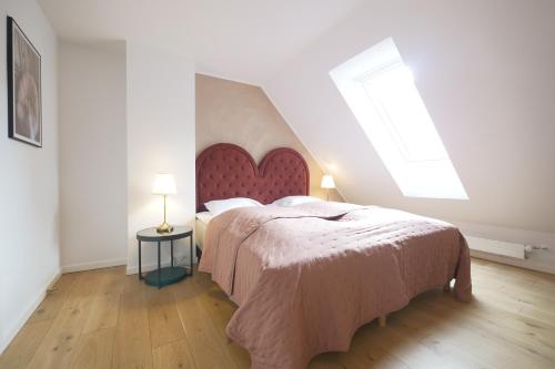 哥本哈根Carolinas Apartment - RAP 5的一间卧室配有一张大床和红色床头板