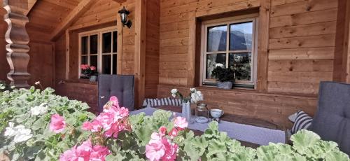 阿尔卑巴赫Alpbach Loft的一座带桌椅和鲜花的木屋