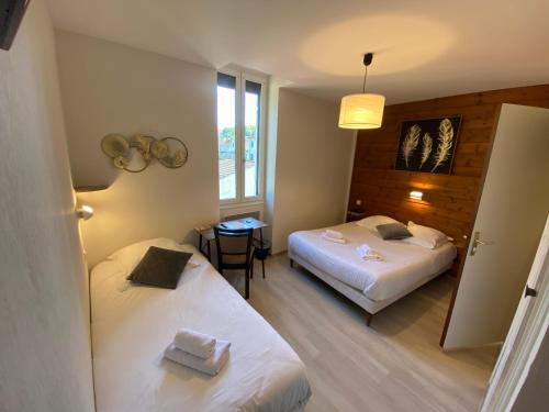 保拉扎克Le Relax的酒店客房设有两张床和一张桌子。