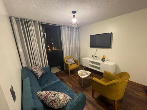 利马Departamento completo Surquillo/Miraflores的客厅配有蓝色的沙发和两把椅子
