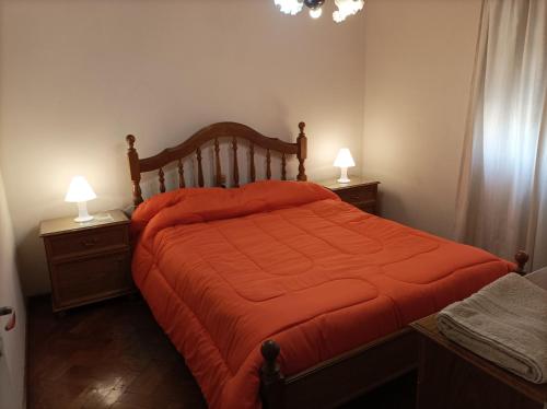 门多萨Hermoso departamento en Mendoza的一间卧室配有一张带橙色棉被的床