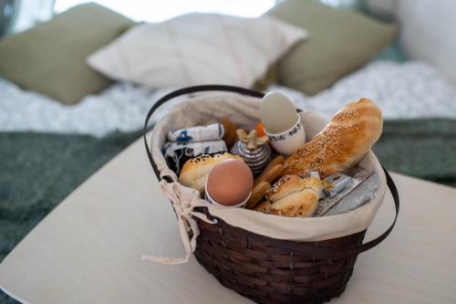 TrzemeśniaBeczki Pod Lasem的桌上的一篮鸡蛋和面包