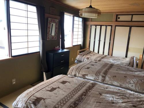 钏路Guest House Nusa - Vacation STAY 12652的卧室设有2张床,带窗户