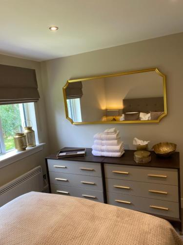 奥赫特拉德Gleneagles Holiday Home的一间卧室配有镜子和一个带毛巾的梳妆台