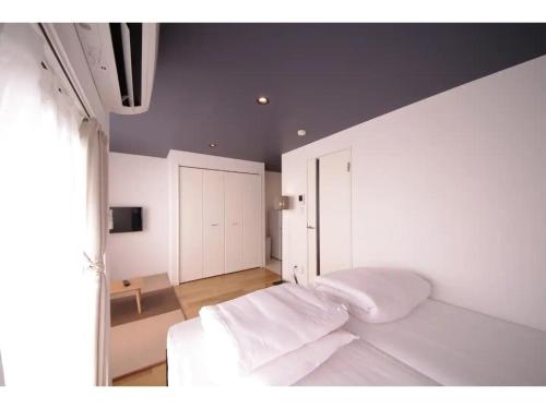 金泽HOTEL APT SESELA - Vacation STAY 12880的一间卧室配有一张带白色床单的床和一扇窗户。
