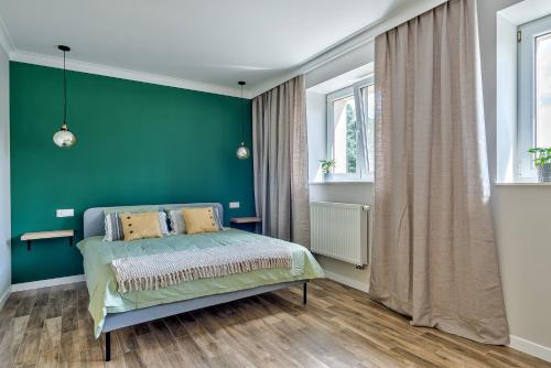 苏普拉希尔Apartament Wschodni的一间卧室设有绿色的墙壁和一张床