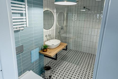 苏普拉希尔Apartament Wschodni的浴室铺有蓝色瓷砖,配有水槽和镜子