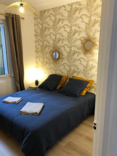乌尔加特L'Air de la Mer, 2 chambres, 50m plage, parking的一间卧室配有一张蓝色的墙壁床
