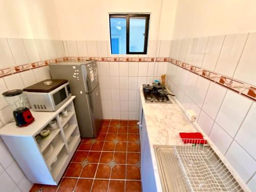 安加罗阿Kahina Lodge的小厨房配有冰箱和微波炉。