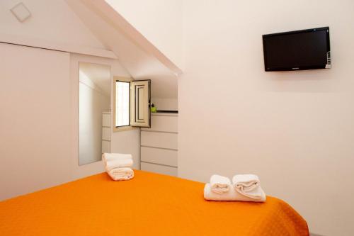 拉古萨码头Endless Summer Apartment的一间配有电视的床上配有2条毛巾的房间