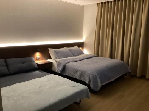 安吉利斯Luxury Condo in Clark Pampanga beside Hilton Hotel and Casino的酒店客房设有两张床和窗户。