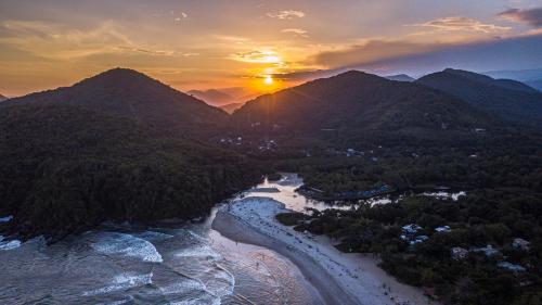 乌巴图巴Hostel Marthi Itamambuca的日落时分享有河流和山脉的空中景致