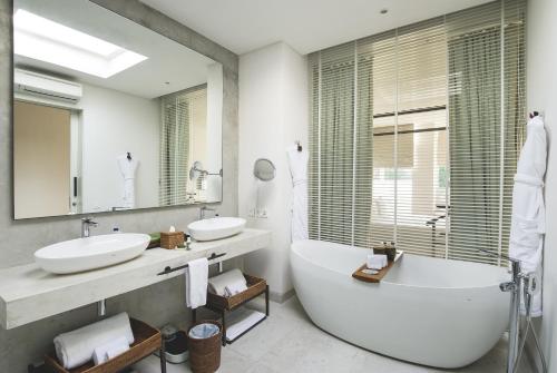 塞米亚克胡武别墅的浴室设有2个水槽、浴缸和镜子