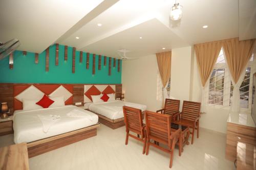 AlānduraiSree Bharat Residency的一间卧室配有两张床和一张桌子及椅子