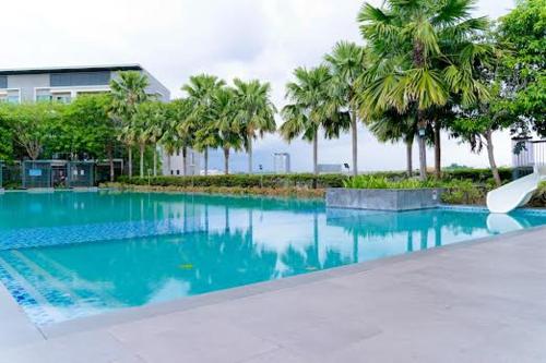 哥打京那巴鲁Bulan Guesthouse Imago的一座棕榈树大型游泳池和一座建筑