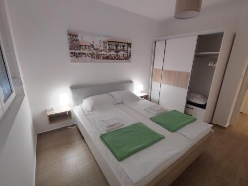 UbLovely one bedroom apartment的卧室配有白色床和2个绿色枕头