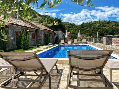 威尔帕扎Eco Villas Merak的一个带两把椅子的庭院和一个游泳池