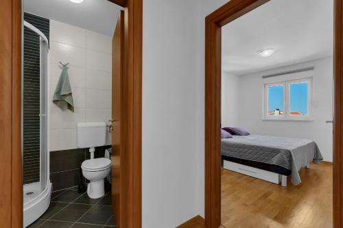 马卡尔斯卡I and A Cozy MAKARSKA的浴室设有床、卫生间和镜子
