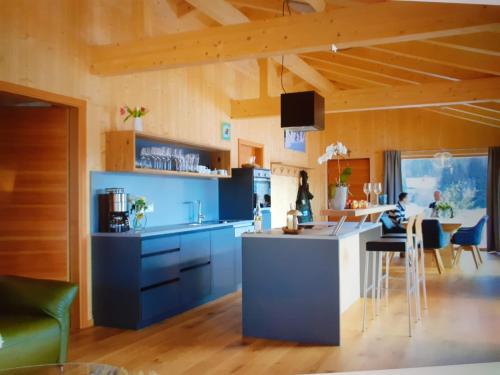 林德伯格Chalet Muehlwiese的厨房配有蓝色橱柜和桌椅