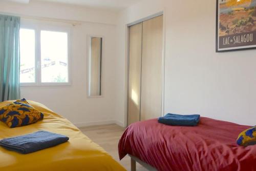 吉尼亚克Néo Cévenols Hostel的客房设有两张床和窗户。