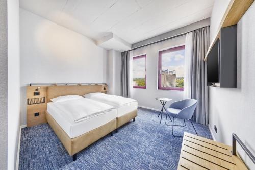 杜塞尔多夫H2 Hotel Düsseldorf Seestern的一间酒店客房,配有一张床和一台电视
