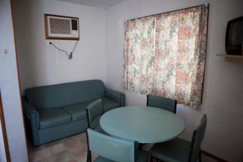 谢珀顿斯特拉叶大篷车公园度假村的客房设有桌子、沙发、桌子和椅子。