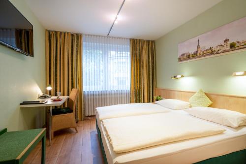 杜塞尔多夫Hotel Arosa Düsseldorf Oberkassel的配有一张床和一张书桌的酒店客房