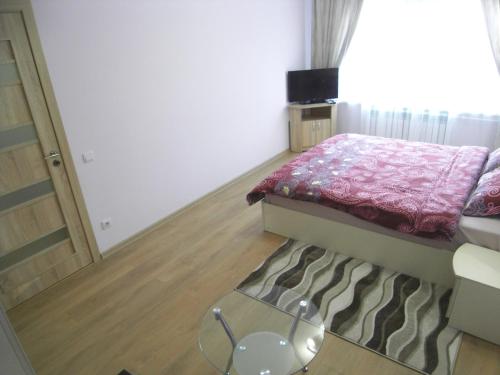基希讷乌现代公寓的一间小卧室,配有一张床和一张玻璃桌