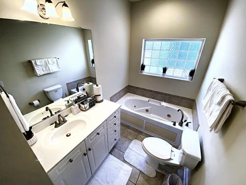 查尔斯顿*Stylish* Luxury Suite Near Historic Downtown的浴室配有盥洗池、卫生间和浴缸。