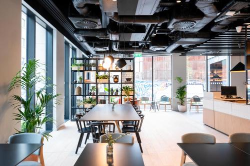 都柏林Staycity Aparthotels Dublin City Quay的用餐室配有桌椅和植物