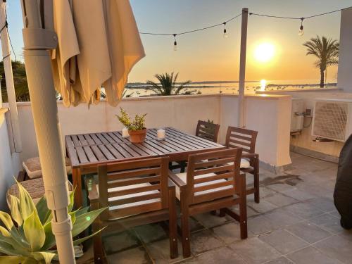 拉萨维纳Ponent Formentera的阳台配有桌椅和遮阳伞